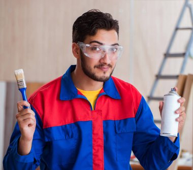 Yooung marangoz boyayla uğraşıyor.