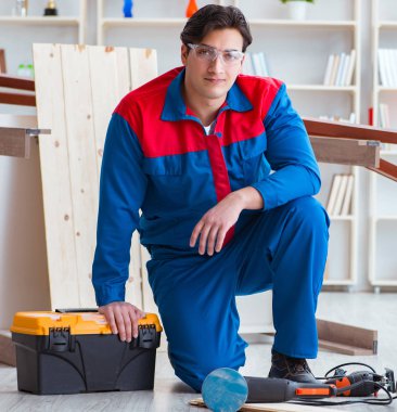 Genç marangoz ahşap kalaslarla çalışıyor.