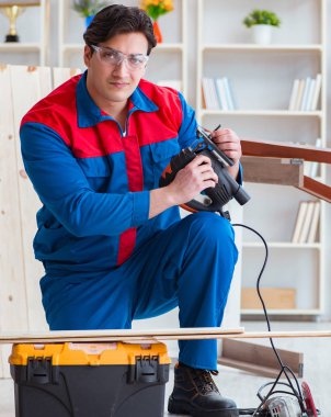 Genç marangoz ahşap kalaslarla çalışıyor.