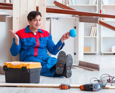 Genç marangoz ahşap kalaslarla çalışmaya ara veriyor.