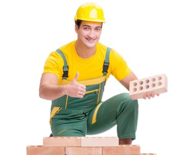 Yakışıklı inşaat işçisi tuğla duvar inşa ediyor.