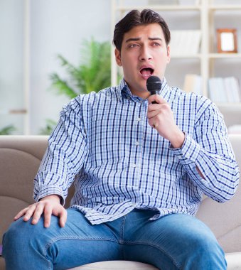 Evde karaoke yapan komik adam.