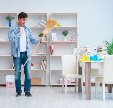 Adam evi temizliyor.