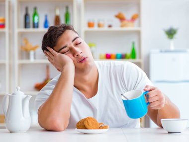 Fazla mesai sonrası kahvaltıda uyuyan bir adam.