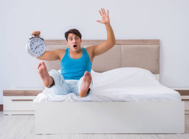 Genç adam yatakta uyanıyor.