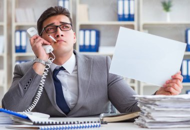 Ofiste sigara içen bir iş adamı elinde boş bir mesaj tutuyor.