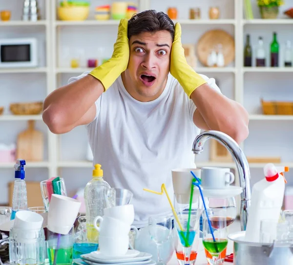Человек расстроен из-за необходимости мыть посуду — стоковое фото