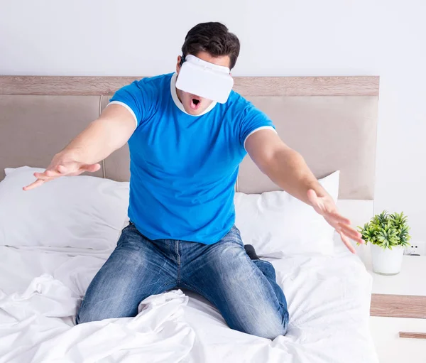 Yatakta sanal gerçeklik başlığı takan genç bir adam.