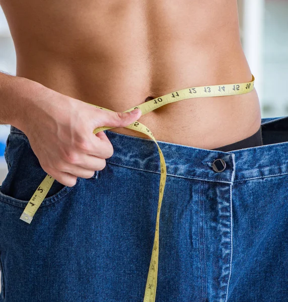 Hombre en pantalones de gran tamaño en concepto de pérdida de peso — Foto de Stock