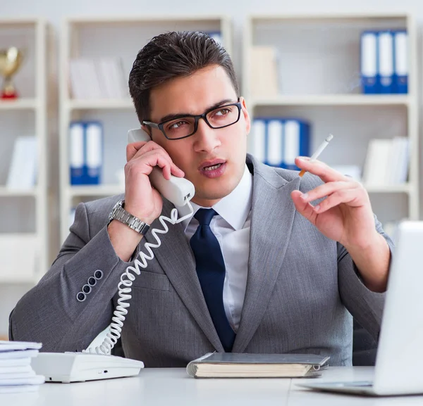 Empresário fumando no escritório no trabalho — Fotografia de Stock