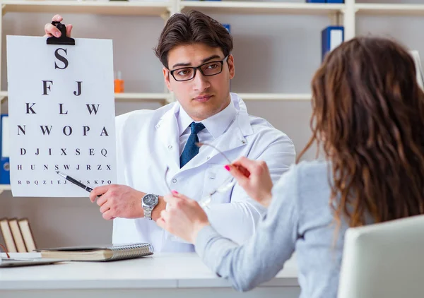 Médecin opticien avec carte postale effectuant un test oculaire — Photo