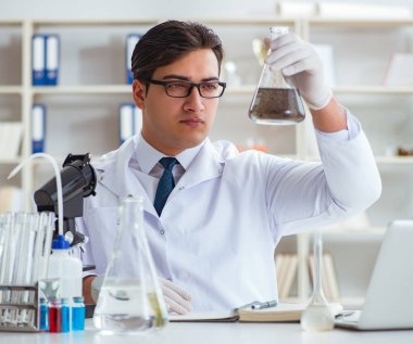 Genç araştırmacı bilim adamı bir su testi kirliliği araştırması yapıyor.