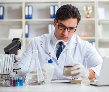 Genç araştırmacı bilim adamı bir su testi kirliliği araştırması yapıyor.