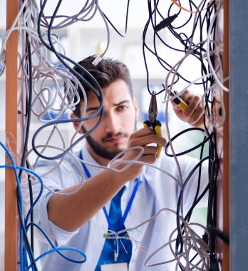 Elektrik teknisyeni tamir konseptinde kabloları çözmeye çalışıyor.