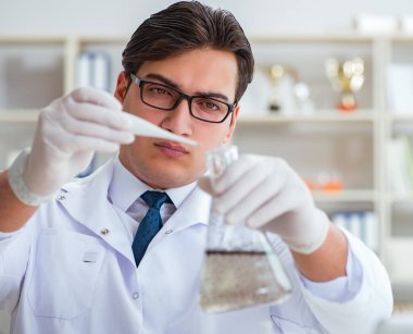 Genç araştırmacı bilim adamı bir su testi kirliliği araştırması yapıyor.