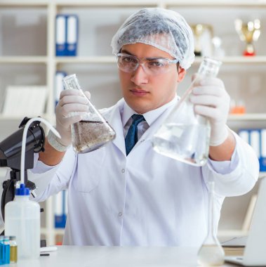 Genç araştırmacı bilim adamı bir su testi kirliliği araştırması yapıyor.