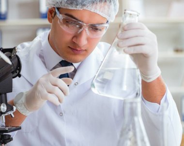 Genç araştırmacı bilim adamı bir su testi kirliliği araştırması yapıyor.