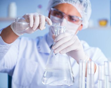 Bir laboratuarda deney yapan kadın bir bilim adamı.