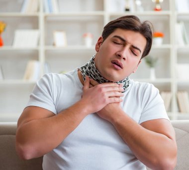 Genç adam boğaz ağrısı çekiyor.