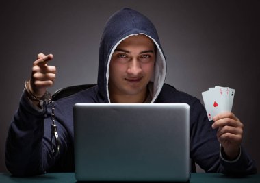 Elleri kelepçeli kapüşonlu genç bir adam Los Angeles 'ın önünde oturuyor.