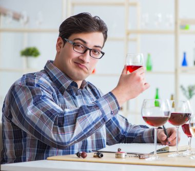 Profesyonel şarap garsonu kırmızı şarap tadıyor.