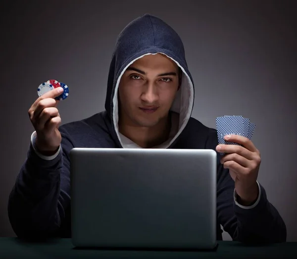 Молодий чоловік у светрі сидить перед портативним комп'ютером — стокове фото