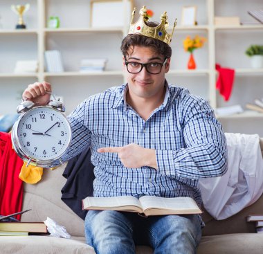 Genç adam dağınık bir odada çalışıyor.