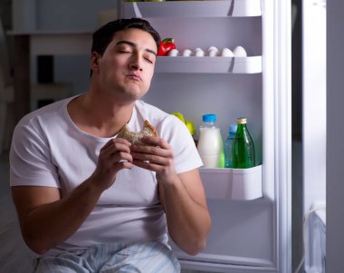 Buzdolabındaki adam gece yemek yiyor.
