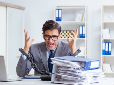 Ofis masasına zincirlenmiş meşgul bir çalışan.