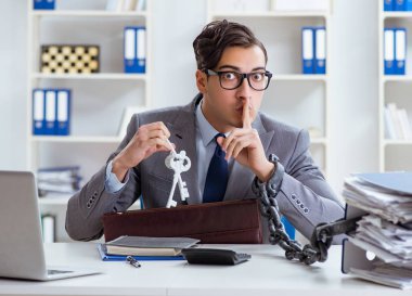 Ofis masasına zincirlenmiş meşgul bir çalışan.