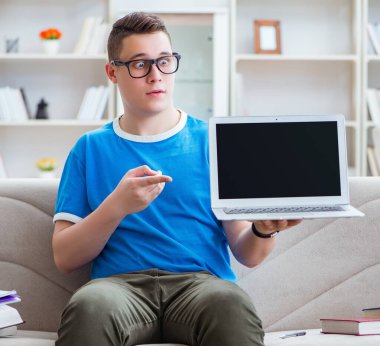 Sınavlara hazırlanan genç öğrenci kanepede ders çalışıyor.