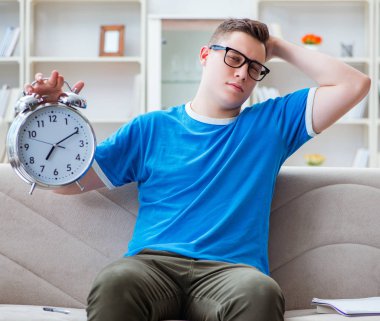 Sınavlara hazırlanan genç öğrenci kanepede ders çalışıyor.