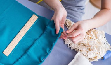 Kadın terzi dikiş dikmek için dikiş dikiyor.