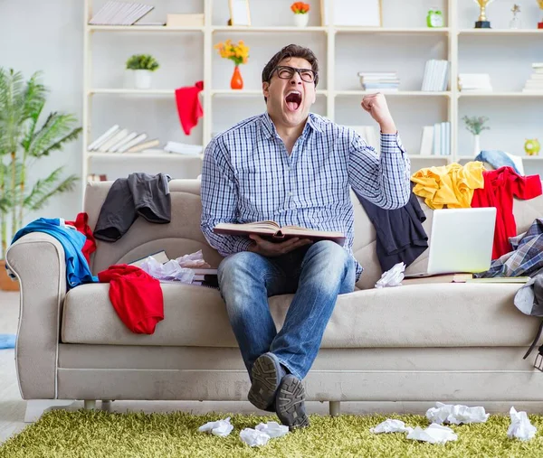 Joven trabajando estudiando en una habitación desordenada — Foto de Stock