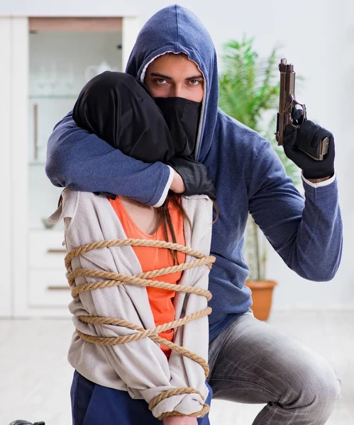 The armed man assaulting young woman at home — Stock Photo, Image