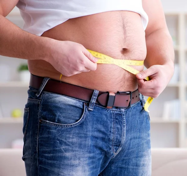 Hombre que sufre de peso extra en concepto de dieta —  Fotos de Stock