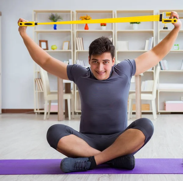 Giovane uomo che esercita a casa in sport e stile di vita sano con — Foto Stock