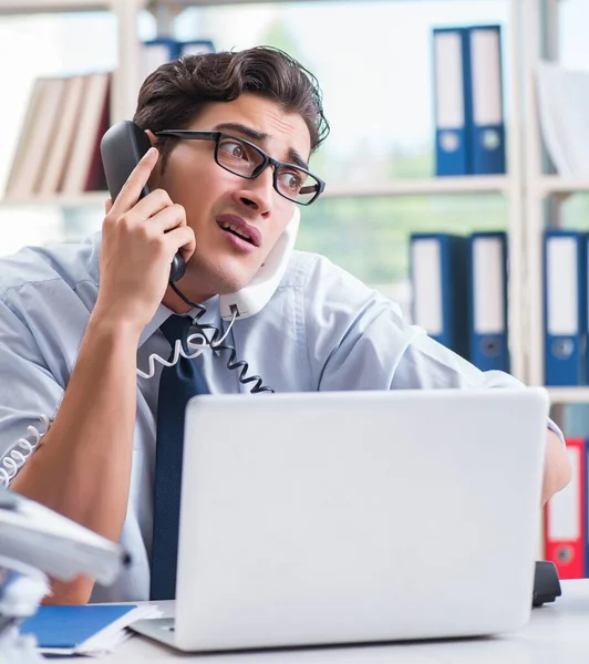 Young businessman under pressure in office to deliver tasks