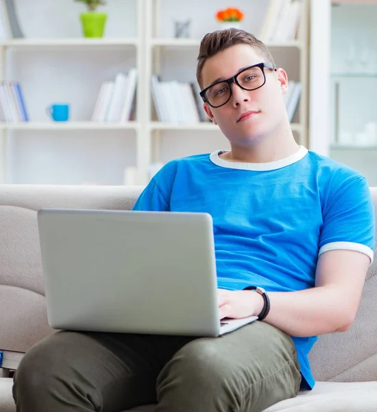 Estudiante joven preparándose para los exámenes que estudian en casa en un sofá — Foto de Stock