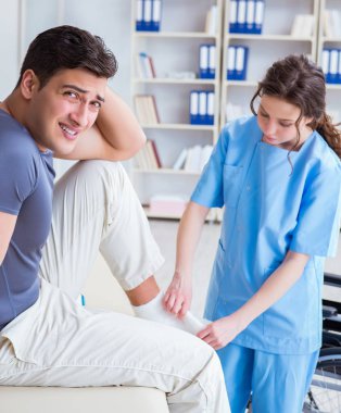 Hastanede yaralanma kontrolü sırasında doktor ve hasta.