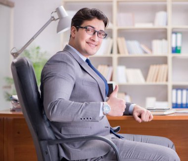 Ofiste çalışan genç bir işadamı.