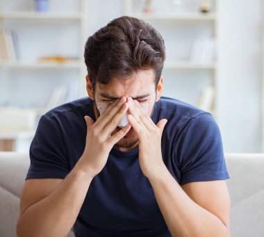 Genç adam estetik cerrahi burnundan sonra evde iyileşiyor.