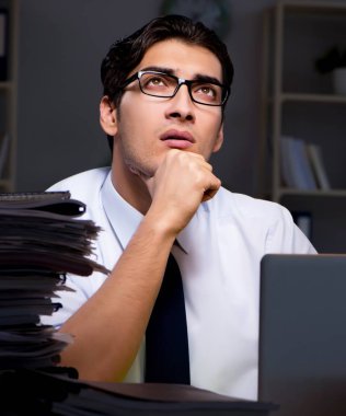 Genç işadamı geç saatlere kadar ofiste çalışıyor.