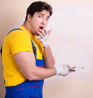 Duvara alçı yapıştıran genç müteahhit.