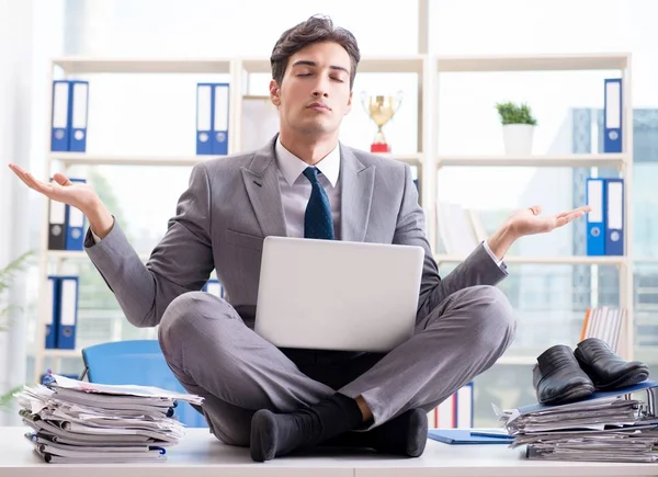 Businessman sitting on top of desk in office — Stock Photo, Image