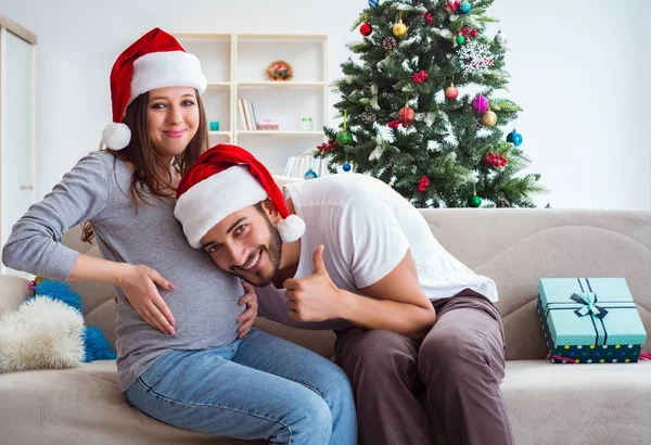 Jeune famille attend bébé célébrant Noël — Photo