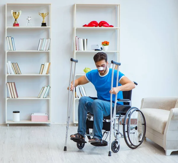 Jongeman herstellende na operatie thuis met krukken en een w — Stockfoto