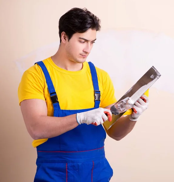 Jonge aannemer die gips op de muur aanbrengt — Stockfoto