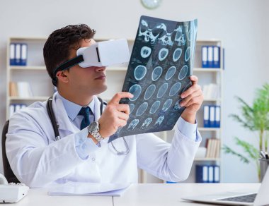 Genç doktor MRI taramasına sanal gerçeklik gözlüğüyle bakıyor.