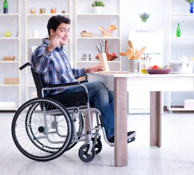 Engelli genç koca mutfakta çalışıyor.